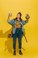 Image showing Portrait of a cheerful young caucasian tourist girl isolated on yellow background