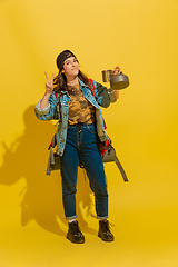 Image showing Portrait of a cheerful young caucasian tourist girl isolated on yellow background