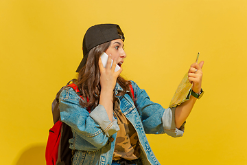 Image showing Portrait of a cheerful young caucasian tourist girl isolated on yellow background