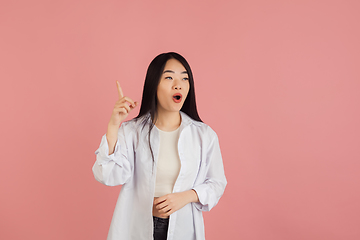 Image showing Asian young woman\'s portrait on pink studio background. Concept of human emotions, facial expression, youth, sales, ad.