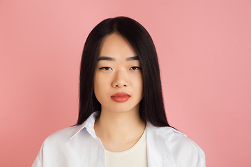 Image showing Asian young woman\'s portrait on pink studio background. Concept of human emotions, facial expression, youth, sales, ad.