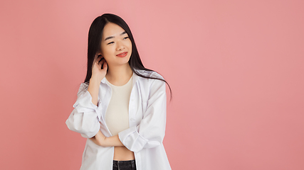 Image showing Asian young woman\'s portrait on pink studio background. Concept of human emotions, facial expression, youth, sales, ad.