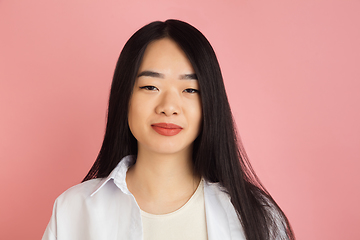 Image showing Asian young woman\'s portrait on pink studio background. Concept of human emotions, facial expression, youth, sales, ad.