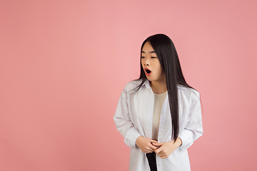 Image showing Asian young woman\'s portrait on pink studio background. Concept of human emotions, facial expression, youth, sales, ad.