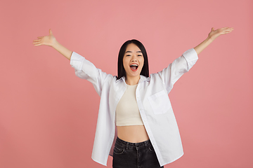 Image showing Asian young woman\'s portrait on pink studio background. Concept of human emotions, facial expression, youth, sales, ad.