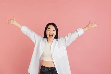 Image showing Asian young woman\'s portrait on pink studio background. Concept of human emotions, facial expression, youth, sales, ad.