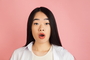 Image showing Asian young woman\'s portrait on pink studio background. Concept of human emotions, facial expression, youth, sales, ad.