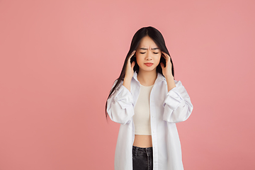 Image showing Asian young woman\'s portrait on pink studio background. Concept of human emotions, facial expression, youth, sales, ad.