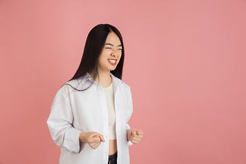 Image showing Asian young woman\'s portrait on pink studio background. Concept of human emotions, facial expression, youth, sales, ad.