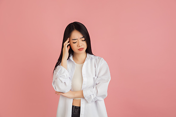 Image showing Asian young woman\'s portrait on pink studio background. Concept of human emotions, facial expression, youth, sales, ad.