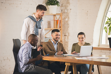 Image showing Colleagues working together in modern office using devices and gadgets during creative meeting