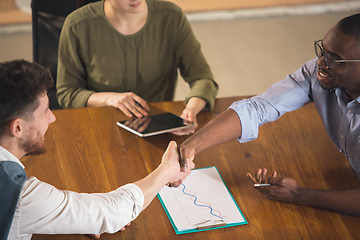 Image showing Colleagues working together in modern office using devices and gadgets during negotiations