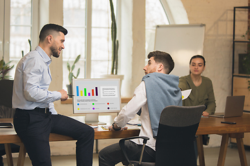 Image showing Colleagues working together in modern office using devices and gadgets during creative meeting