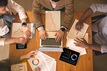 Image showing Top view, close up. Colleagues working together in modern office using devices and gadgets during creative meeting