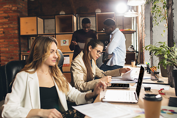 Image showing Colleagues working together in modern office using devices and gadgets during negotiations