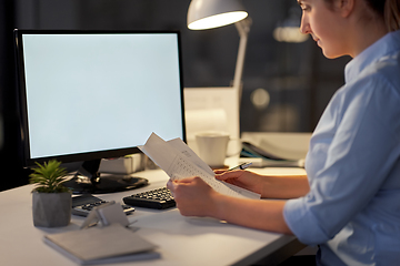 Image showing businesswoman with papers working at night office