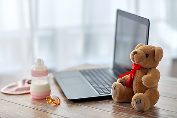 Image showing baby milk formula, laptop, soother and teddy bear