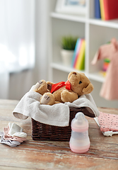 Image showing teddy bear toy in basket with baby things on table