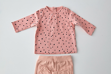 Image showing pink shirt and pants for baby girl over white