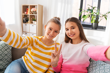 Image showing happy teenage girls taking selfie at home