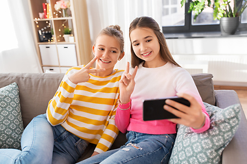 Image showing happy girls taking selfie with smartphone at home