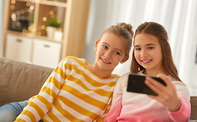 Image showing happy girls taking selfie with smartphone at home