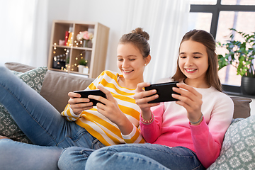 Image showing happy teenage girls with smartphones at home