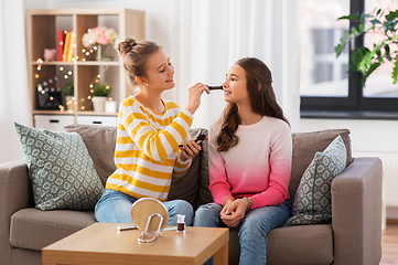 Image showing happy teenage girls doing make up at home