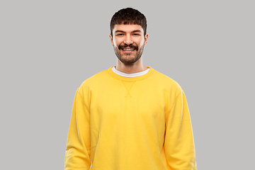 Image showing smiling young man in yellow sweatshirt