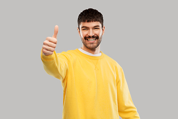 Image showing smiling young man showing thumbs up