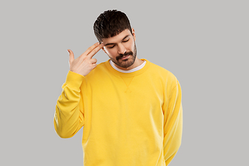 Image showing bored man making finger gun gesture