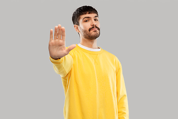 Image showing serious young man showing stop gesture