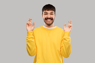 Image showing smiling man with crossed fingers
