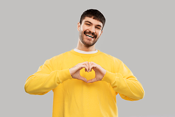 Image showing smiling young man in yellow sweatshirt