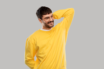 Image showing smiling young man in glasses and yellow sweatshirt