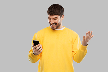 Image showing happy smiling young man with smartphone