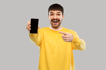 Image showing happy smiling young man showing smartphone