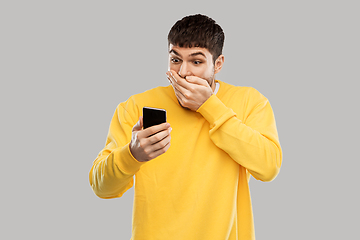 Image showing shocked young man with smartphone