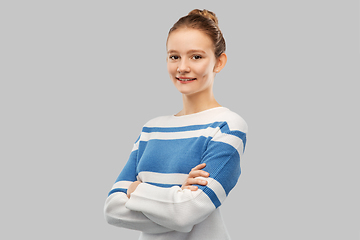 Image showing smiling teenage girl with crossed arms in pullover