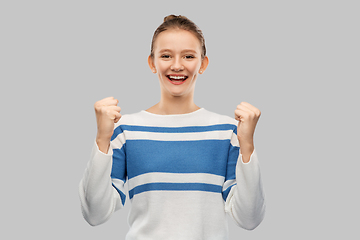 Image showing happy teenage girl in pullover celebrating success