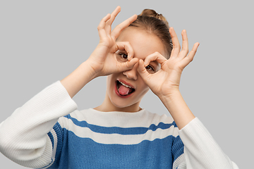 Image showing funny teenage girl looking through finger glasses