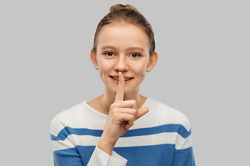 Image showing smiling teenage girl with finger on lips