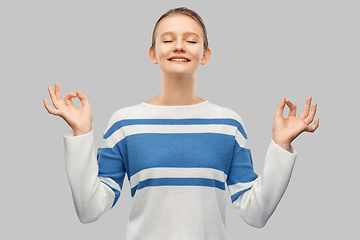 Image showing happy smiling teenage girl in pullover meditating