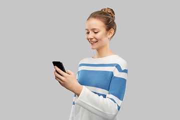Image showing happy smiling teenage girl using smartphone