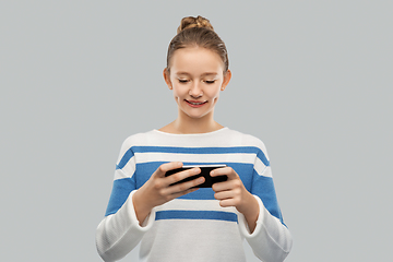 Image showing happy smiling teenage girl using smartphone