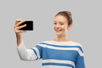 Image showing smiling teenage girl taking selfie with smartphone