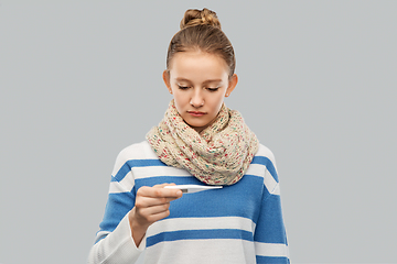 Image showing sick teenage girl in scarf measuring temperature