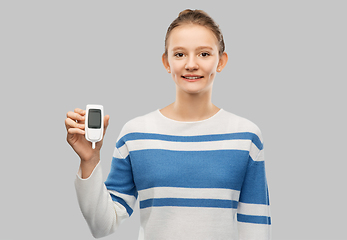 Image showing happy smiling teenage girl with glucometer