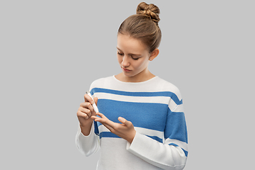 Image showing teenage girl making blood sugar test by glucometer