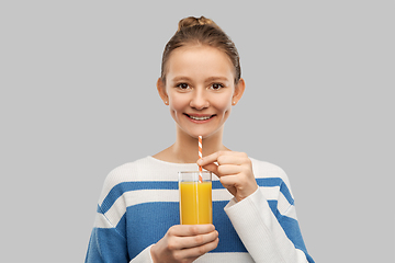 Image showing smiling teenage girl holding glass of orange juice